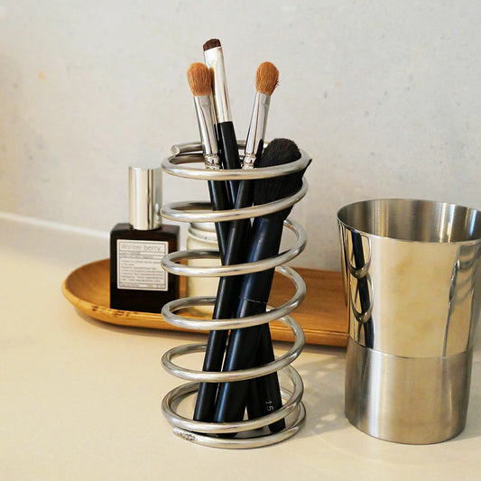 洗面台に置かれたスプリングホルダー。メイクブラシを立てたおしゃれな韓国インテリア風の収納イメージ。