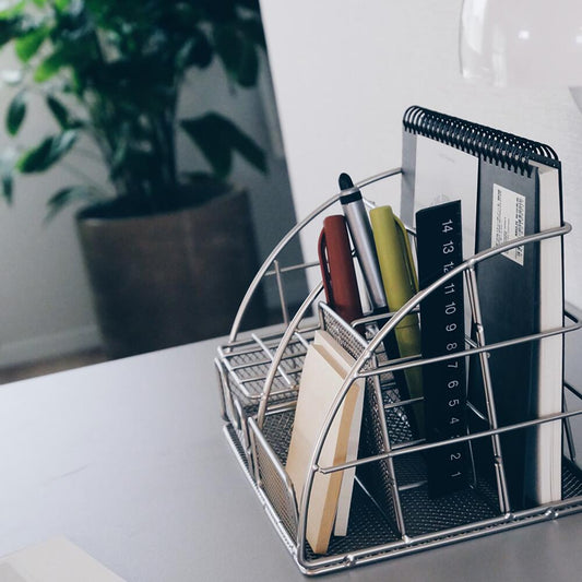 シルバー製デスクオーガナイザーの全体像。ペンやメモ帳など文房具をスマートに収納したデスク上の使用例。