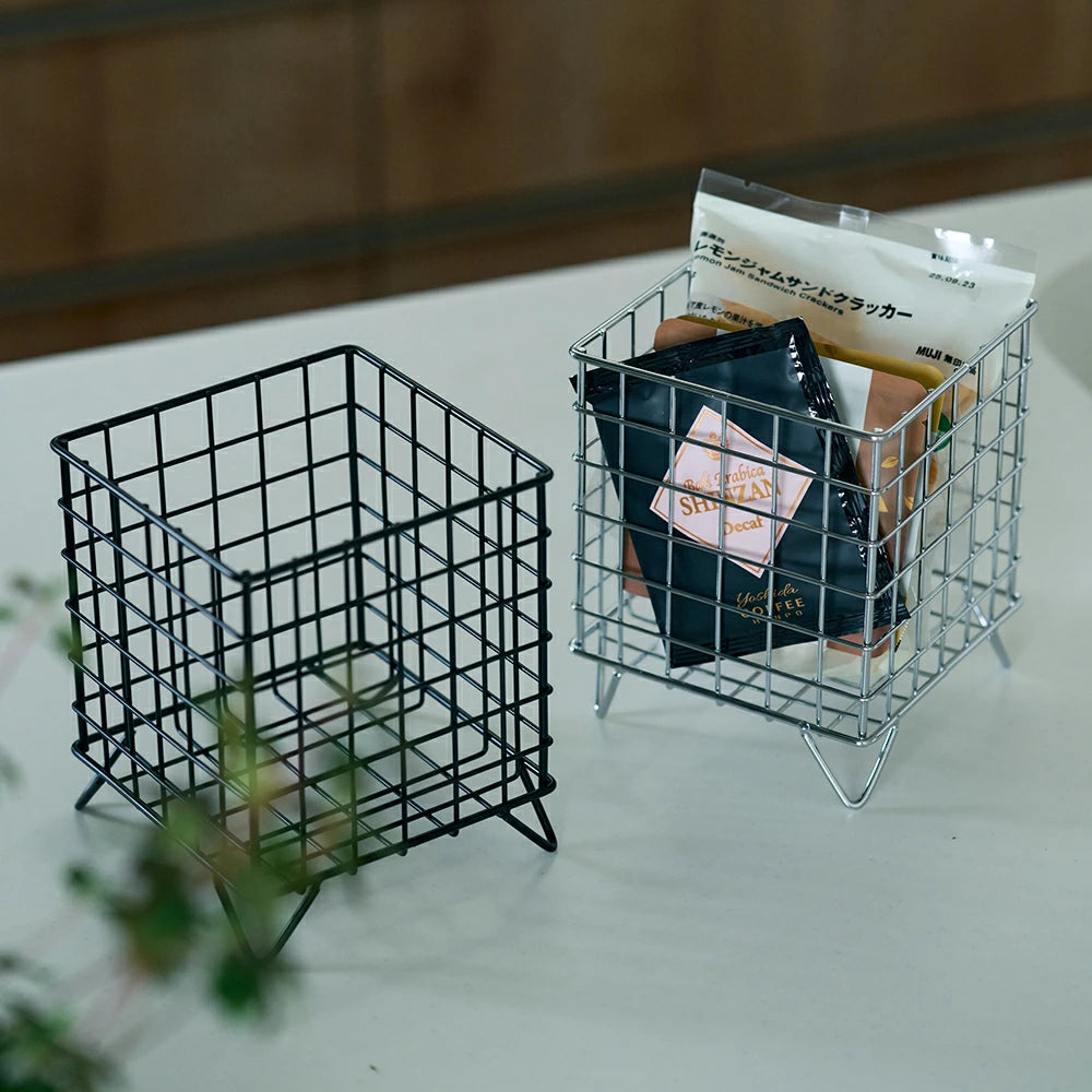 シルバーとブラックのワイヤーバスケットの全体像。キッチンカウンターに置かれた、カフェポーションやティーバッグの収納例。シンプルでスタイリッシュな角型デザインがわかる画像。